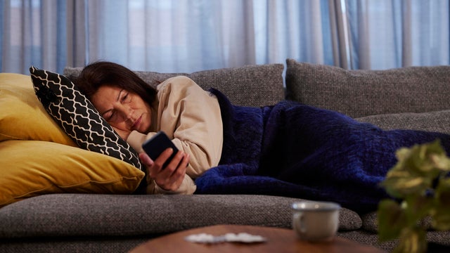 Woman on sofa using cell phone 