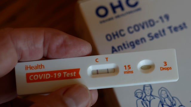 A woman using Covid-19 rapid self-test kit at home